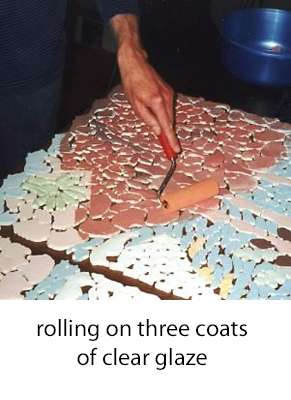 using a paint roller to glaze the colored tiles