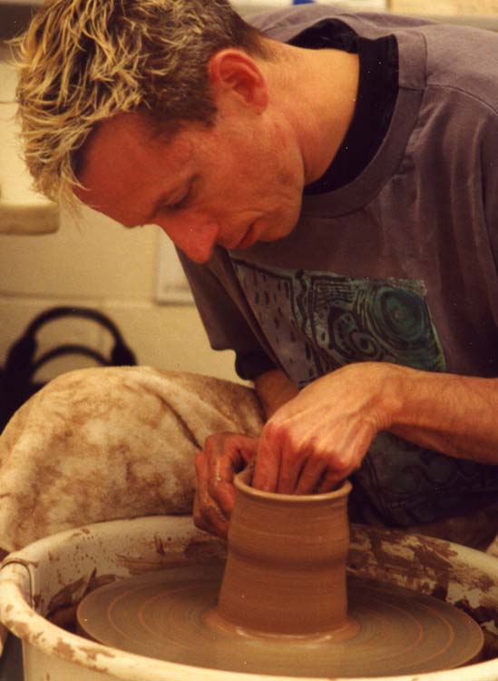 Rick Hoffman makes a clay cylinder on the pottery wheel